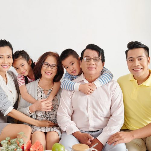 Portrait of happy big Vietnamese family gathered at home for dinner